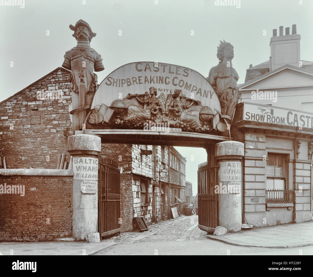 Ships' figureheads over the gate at Castle's Shipbreaking Yard, Westminster, London, 1909. Artist: Unknown. Stock Photo