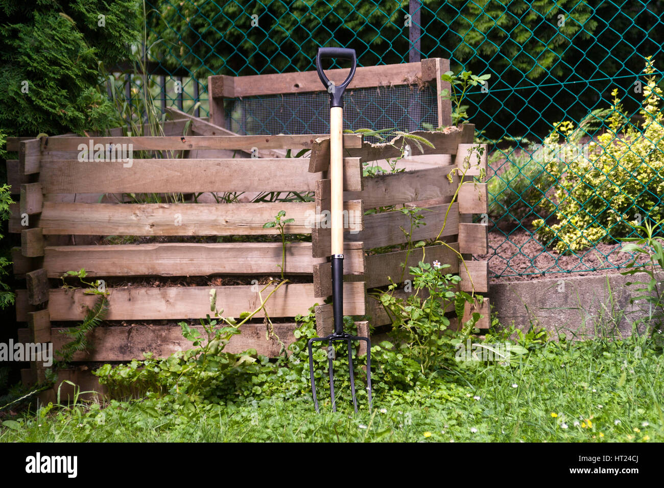 pitch fork at a wooden compost pile frame Stock Photo