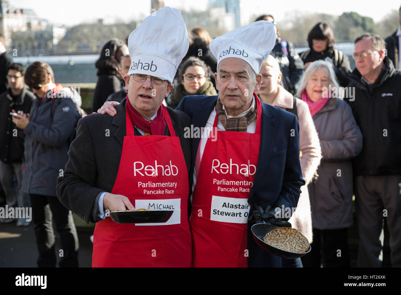 Michael Crick(L), Political Correspondent, Channel 4 News and Alastair Stewart OBE(R), Presenter, ITV News. MPs, Lords and Media attend the 20th Annual Rehab Parliamentary Pancake Race at Victoria Gardens in Westminster, London, UK. Stock Photo