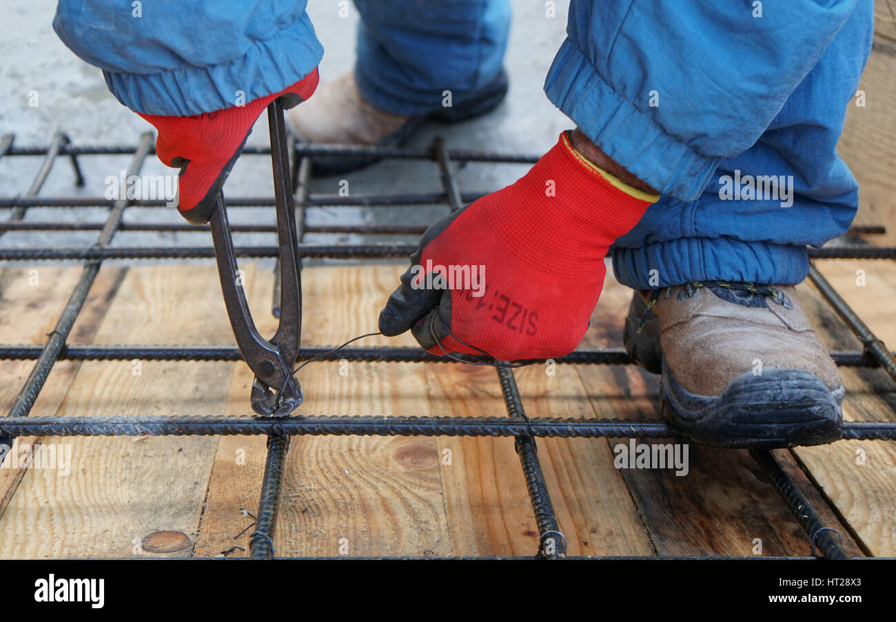 Construction worker working on steel rods used to reinforce concrete ...