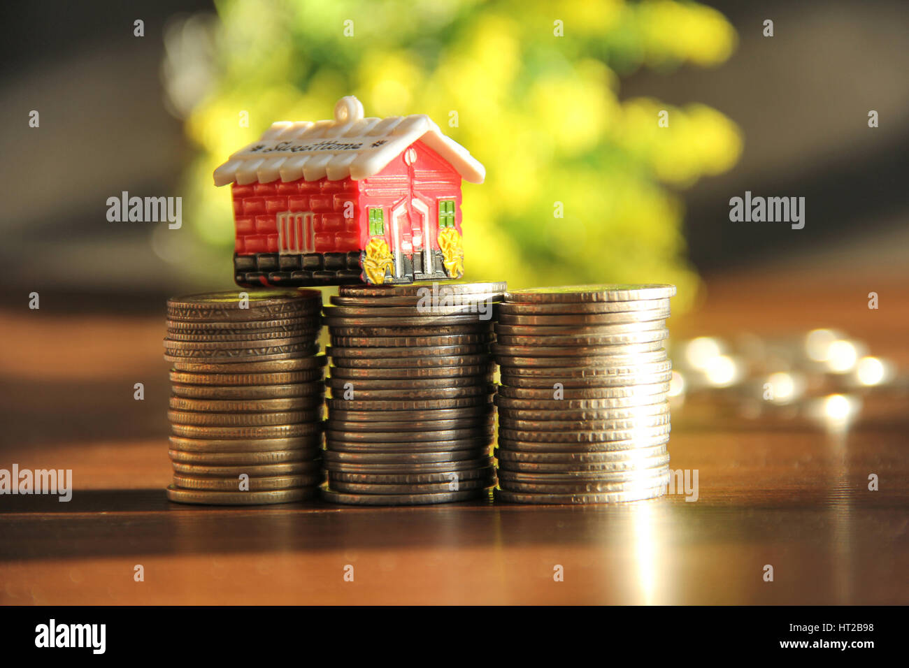 Saving money to buy house or home. Piggy bank with stack of coins Stock Photo
