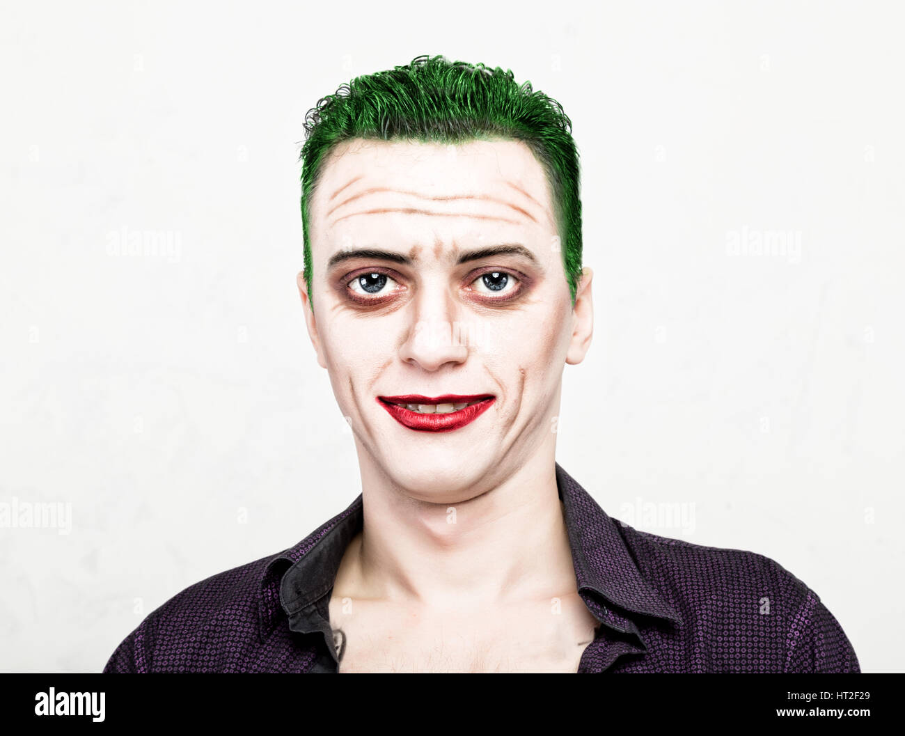 guy with crazy joker face, green hair and idiotic smike. carnaval costume. Stock Photo