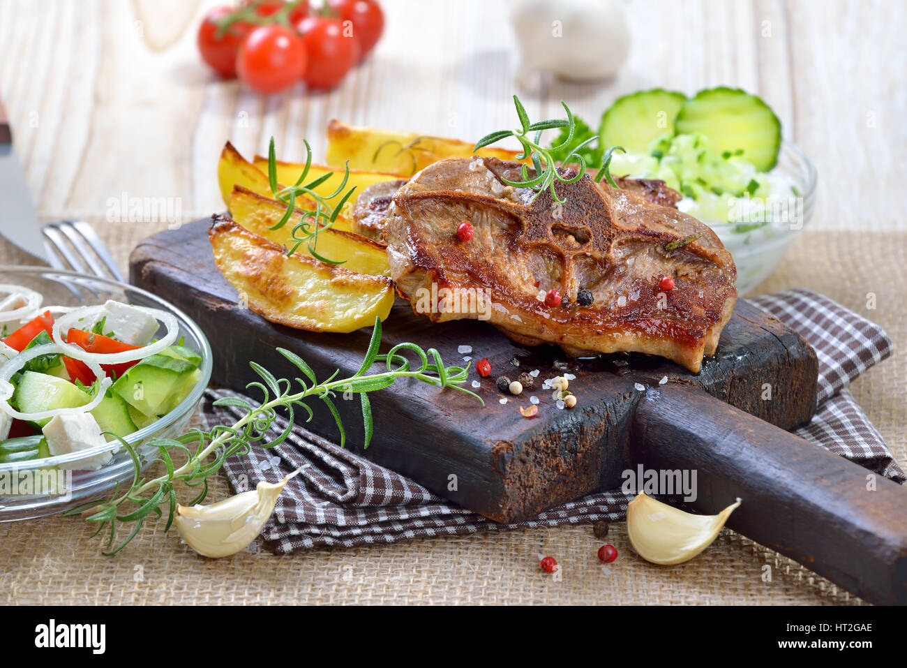 Greek meal Fried lamb chops with baked potato wedges, farmers salad