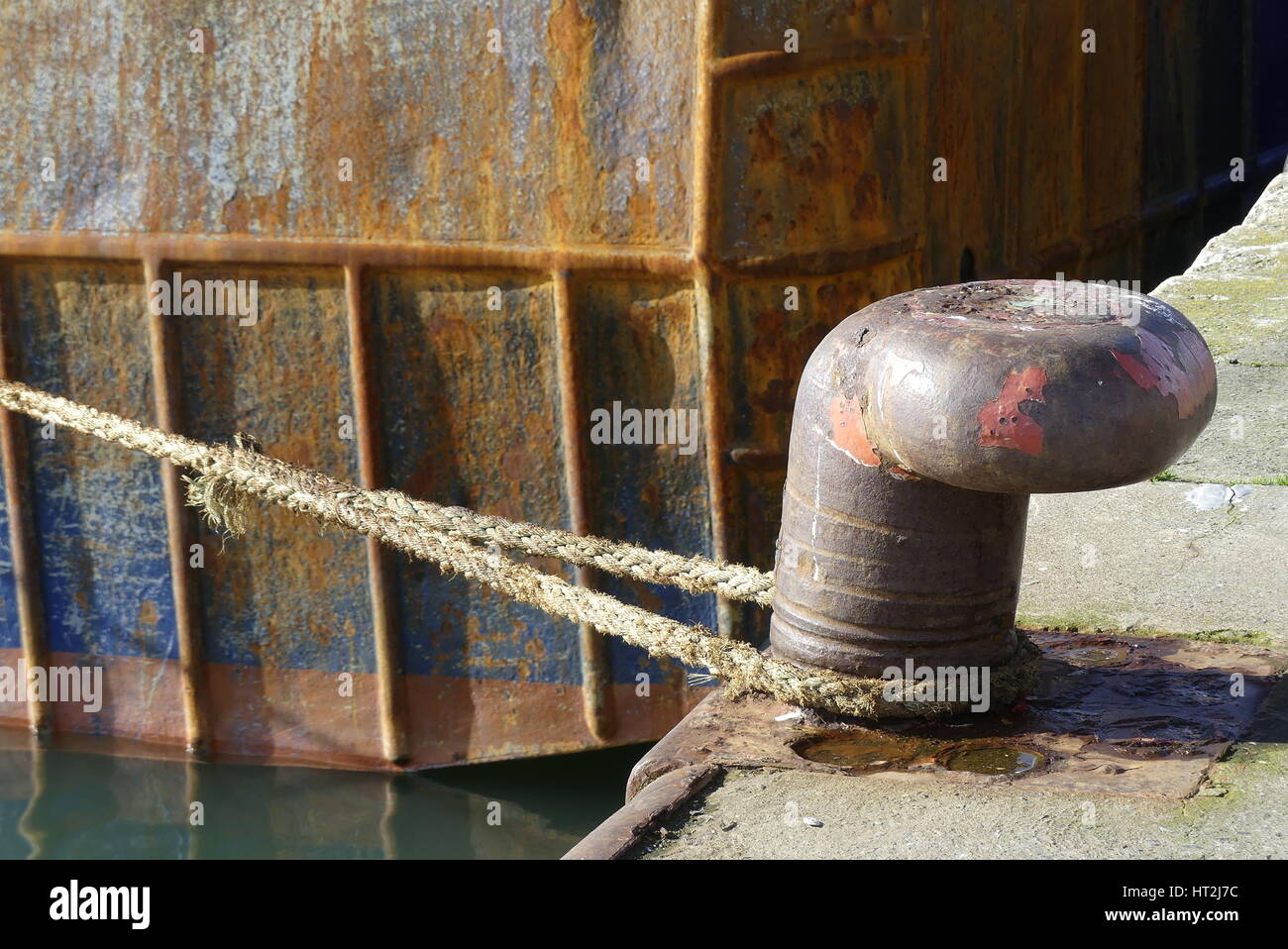 Rusty bollard and mooring rope in the fishing harbor of Lorient, Brittany France. Stock Photo