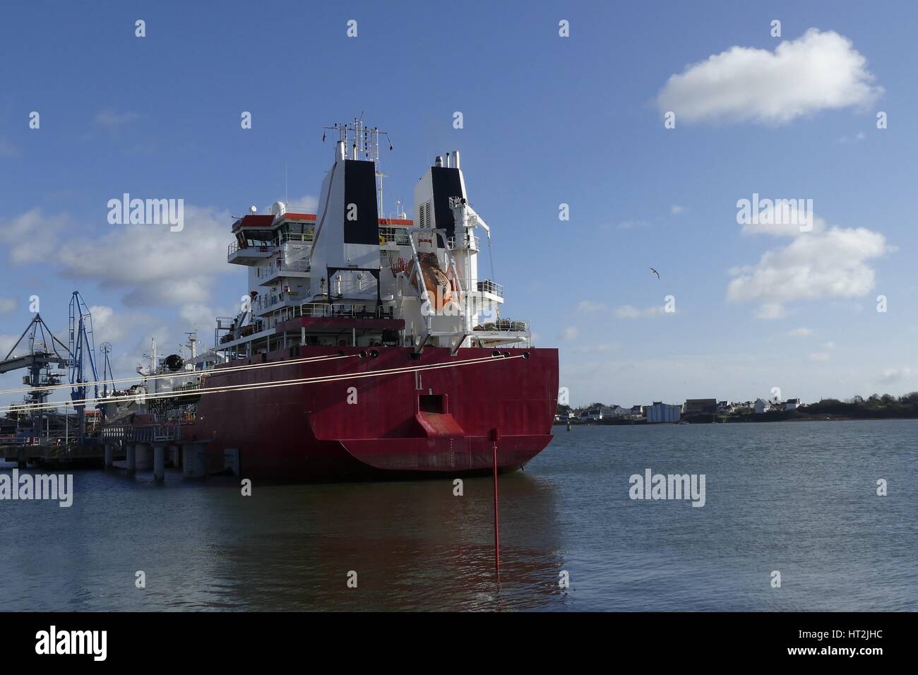Products Tanker discharging at the Oil Terminal of Lorient, France, with red hull and white funnel on a sunny day. Stock Photo
