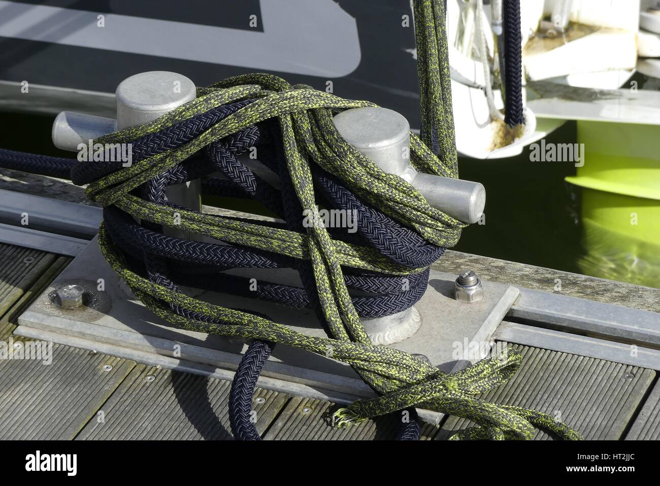 Details of mooring arrangement on aluminum bollard at the marina with mooring ropes tied around. Stock Photo
