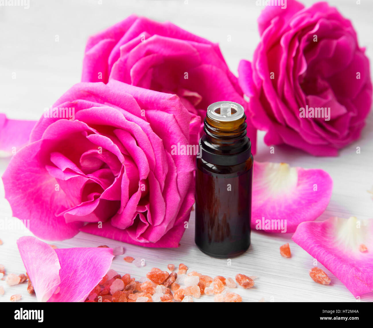 Roses spa essence bottle with roses flowers and petals Stock Photo - Alamy