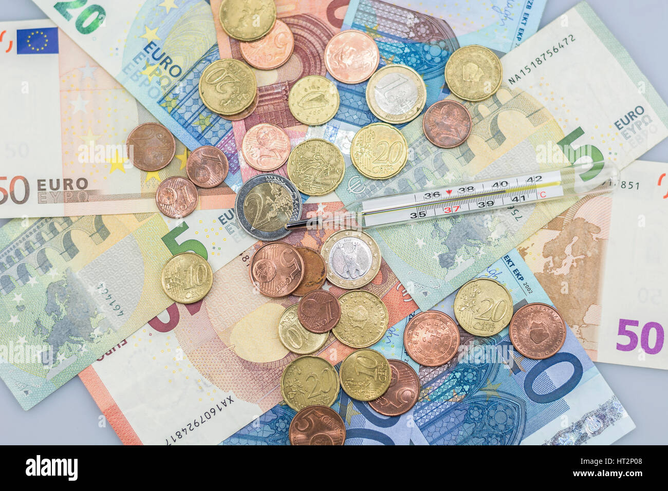 Thermometer on a pile of euros to symbolize the concerns about the euro. Stock Photo