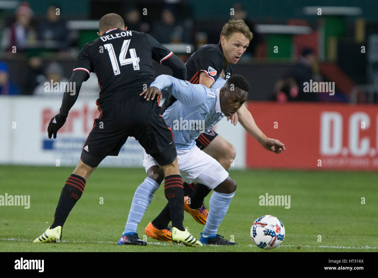 Sporting Kansas City forward Gerso Fernades (7) fights off D.C. United midfielder Nick DeLeon (14) and D.C. United defender Taylor Kemp (2) during D.C. United's home opener against Sporting Kansas City which finished 0-0 at RFK Stadium in Washington, D.C. Stock Photo