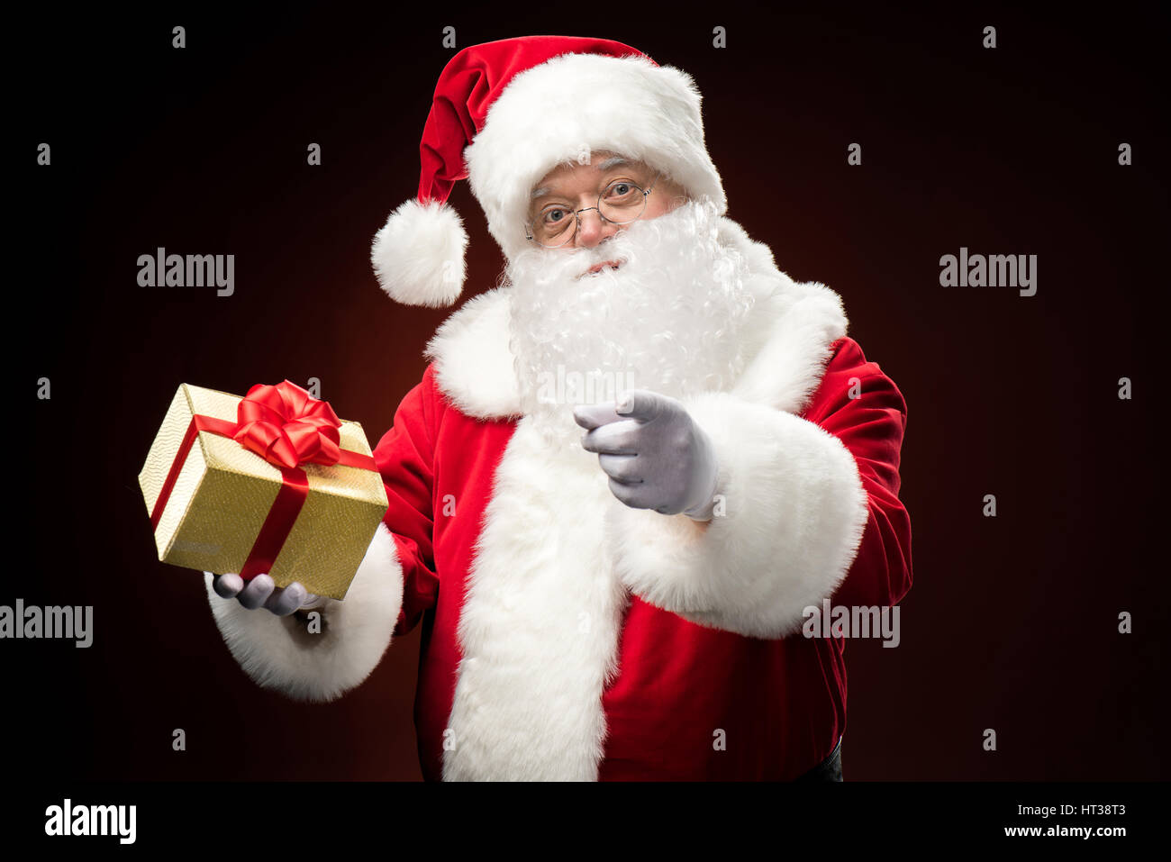 Santa Claus with gift box in hand Stock Photo - Alamy