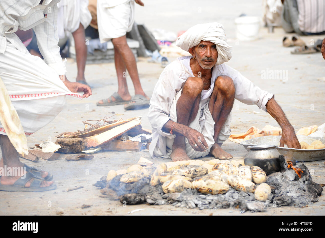 A man bakes bread on hot embers in Rajasthan Stock Photo