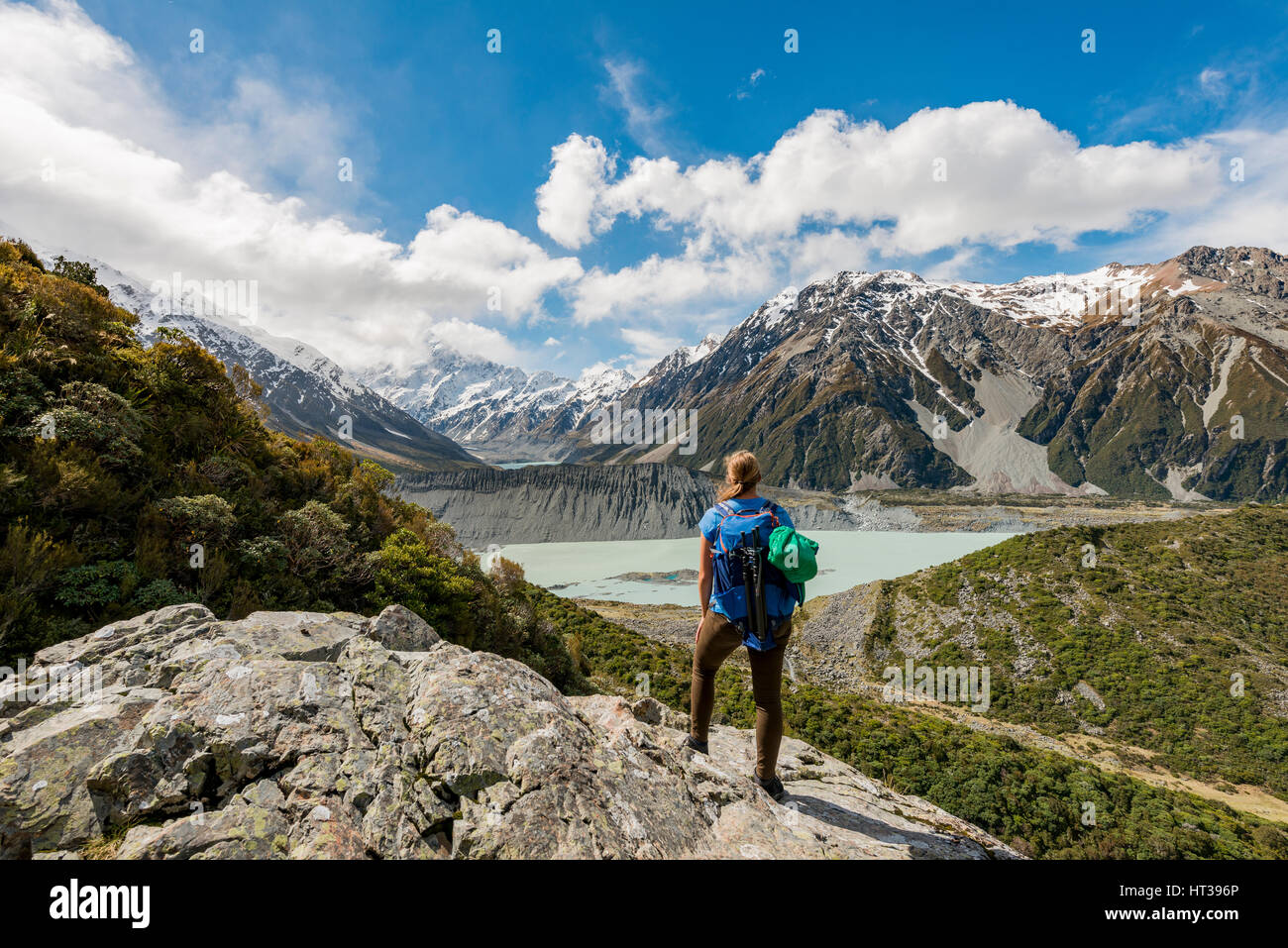Hiker standing on rocks, view into the Hooker Valley from Sealy Tarns Track, glacial lakes Mueller Lake and Hooker Lake Stock Photo