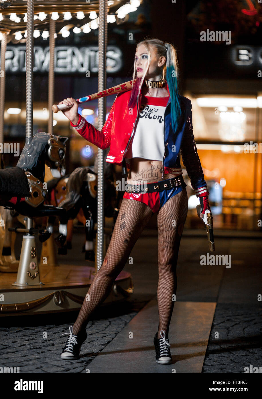 Cosplayer girl in costume Harley Quinn on background lights of night city. Cosplay Stock Photo