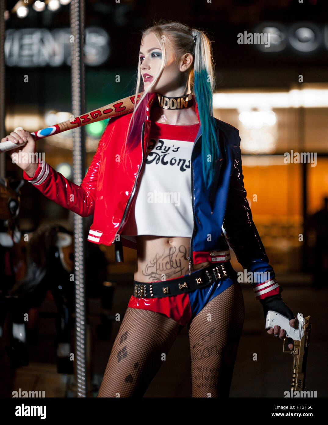Portrait of cosplayer girl in costume Harley Quinn on background lights of night city. Cosplay Stock Photo