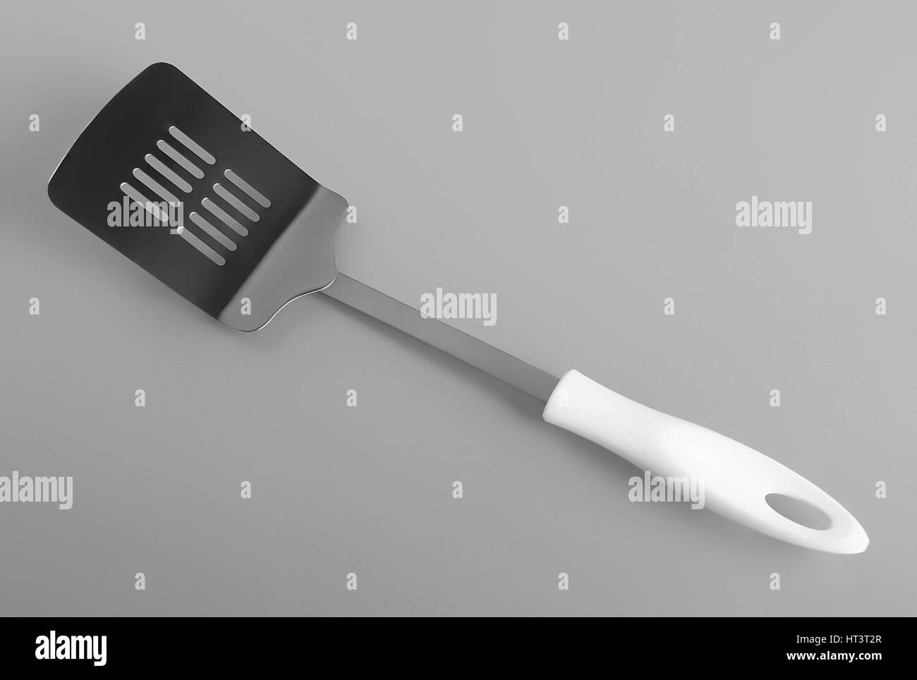 Metal cooking kitchen spatula on gray background Stock Photo