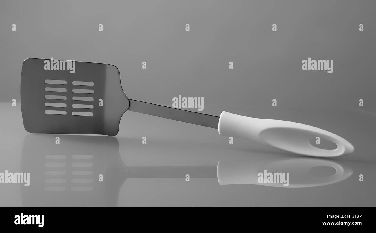 Metal cooking kitchen spatula on gray background Stock Photo