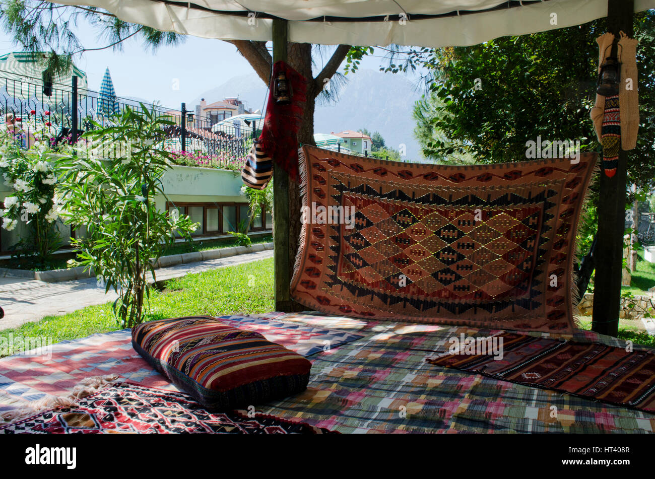 chillout seating area on turkish mats, carpets with cusions strewn out in the midday turkish sun Stock Photo