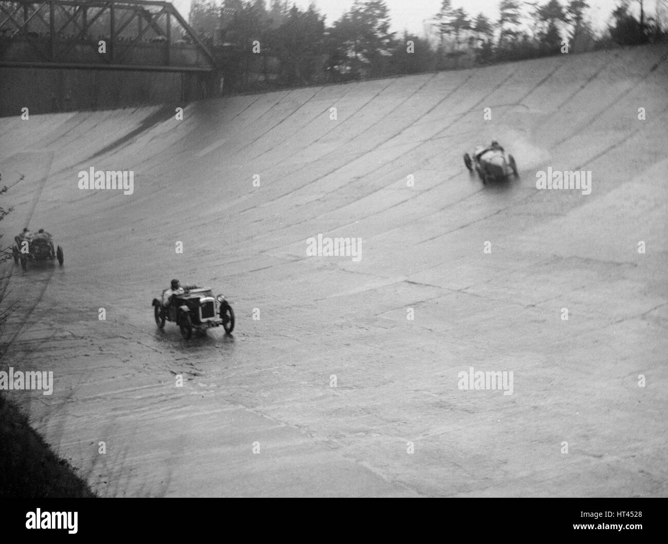 Austin 7 and the spinning Riley of HL Roberts, BARC Mountain Race, Brooklands, Surrey, 1931 Artist: Bill Brunell. Stock Photo
