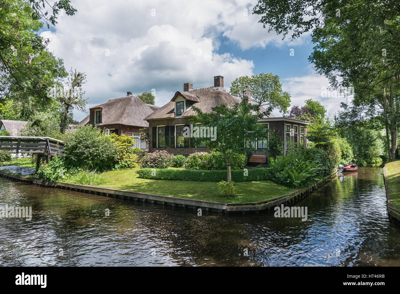 Giethoorn, Netherlands – June 29, 2016: View of a blooming garden in front of the house of the Dutch town Giethoorn. Stock Photo