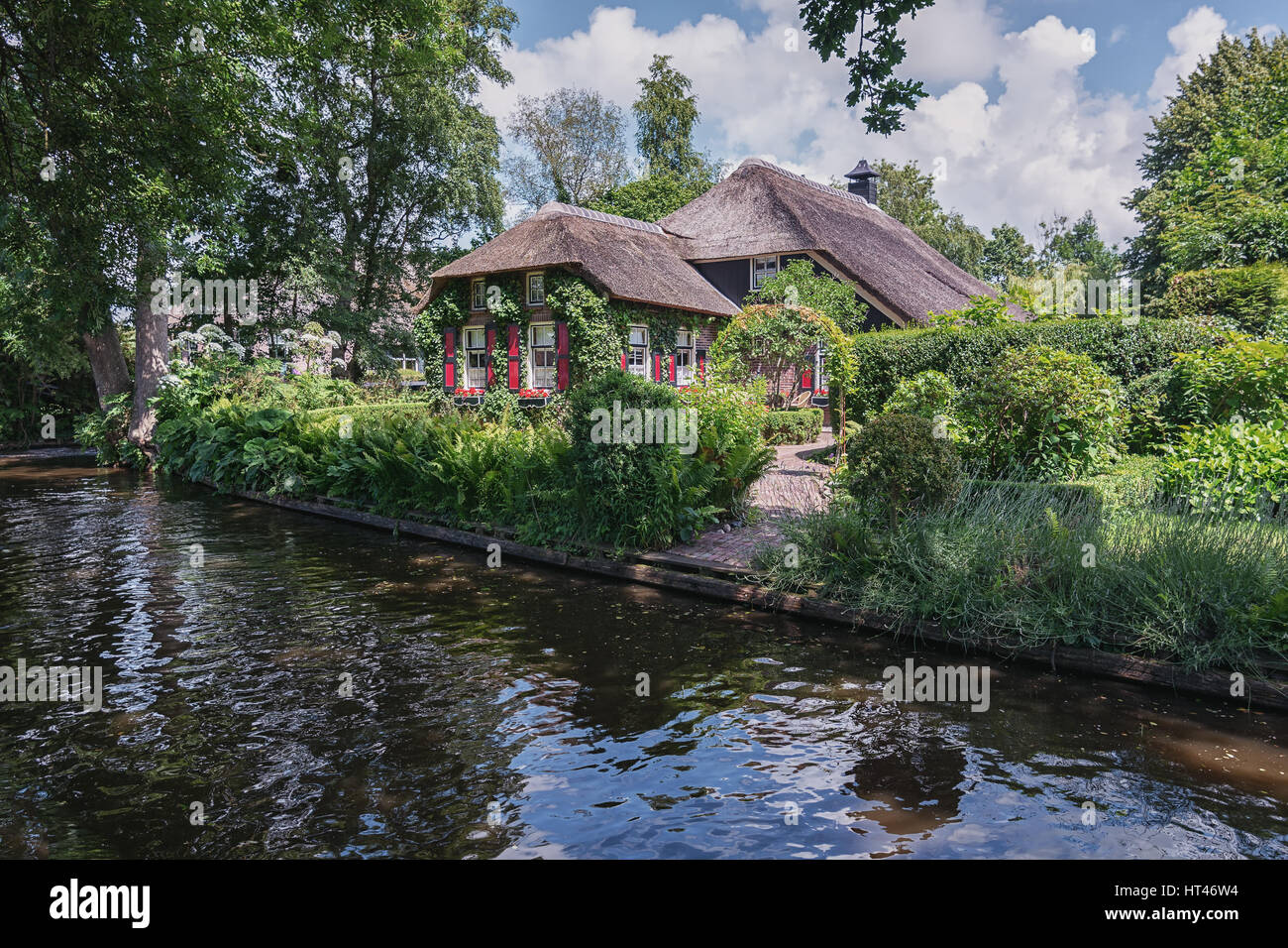Giethoorn, Netherlands – June 29, 2016:  View of a blooming garden in front of the house of the Dutch town Giethoorn. Stock Photo