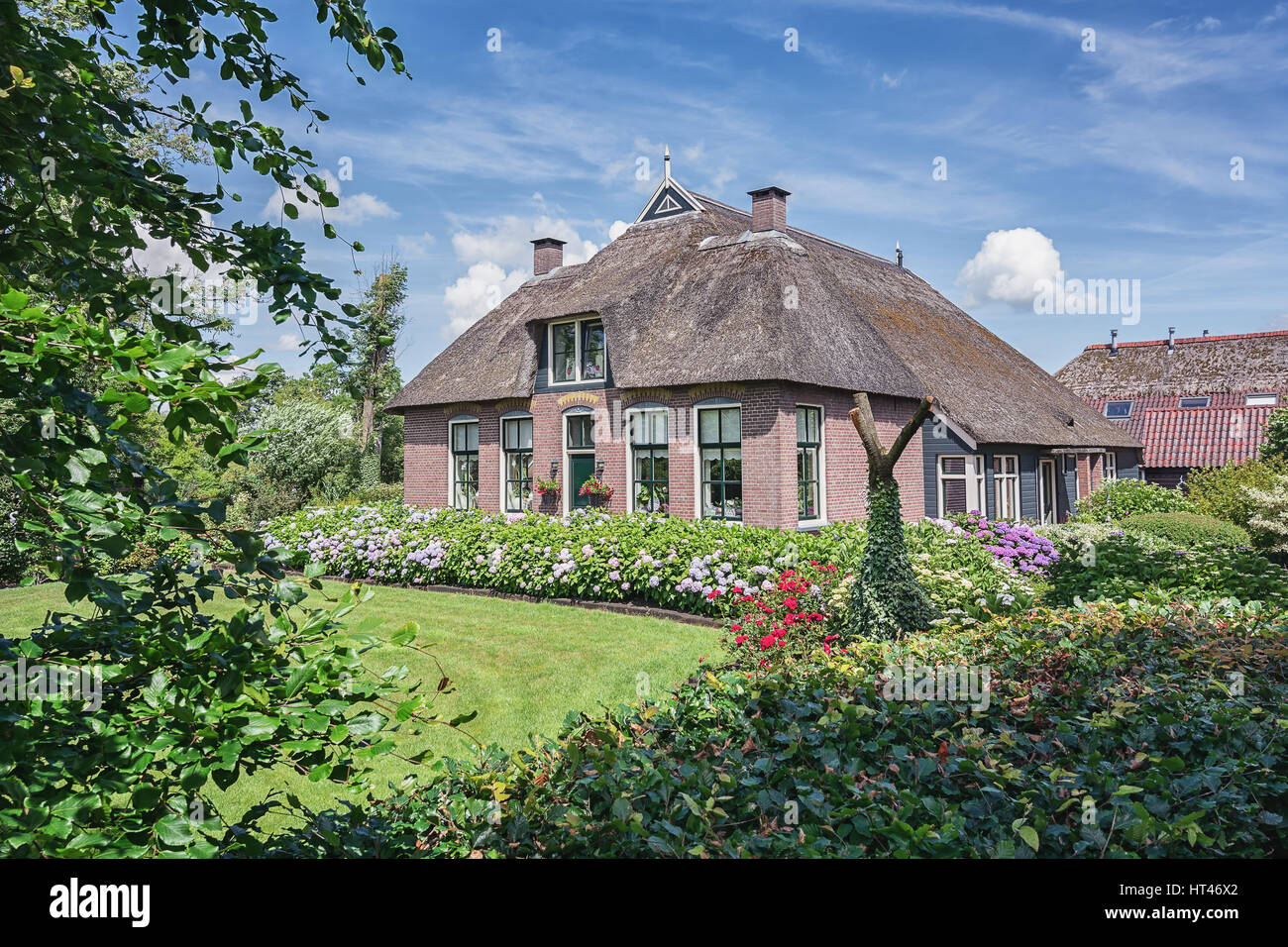 Giethoorn, Netherlands – June 29, 2016: View of a blooming garden in front of the house of the Dutch town Giethoorn. Stock Photo