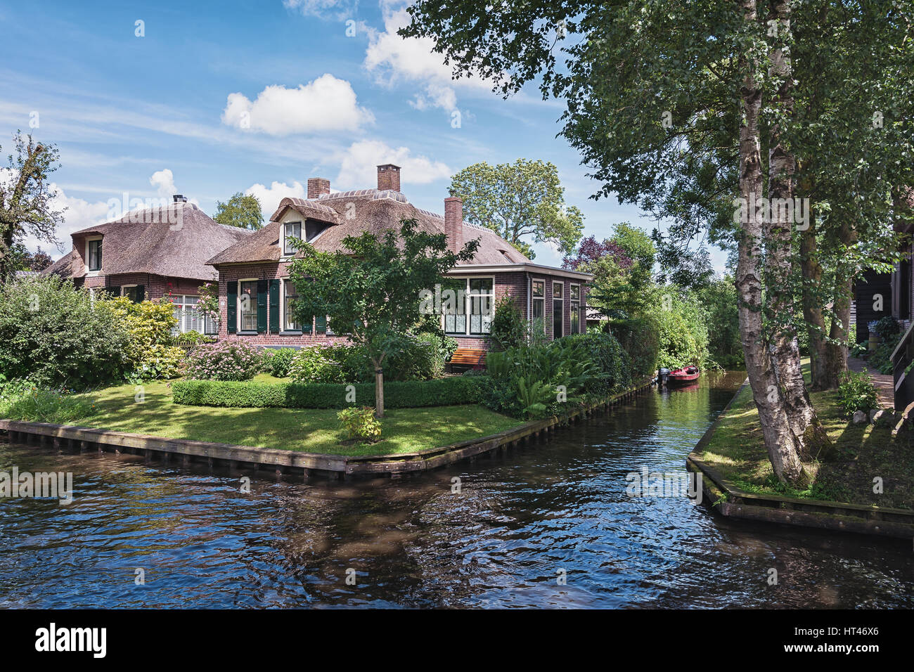 Giethoorn, Netherlands – June 29, 2016: View of a blooming garden in front of the house of the Dutch town Giethoorn. Stock Photo