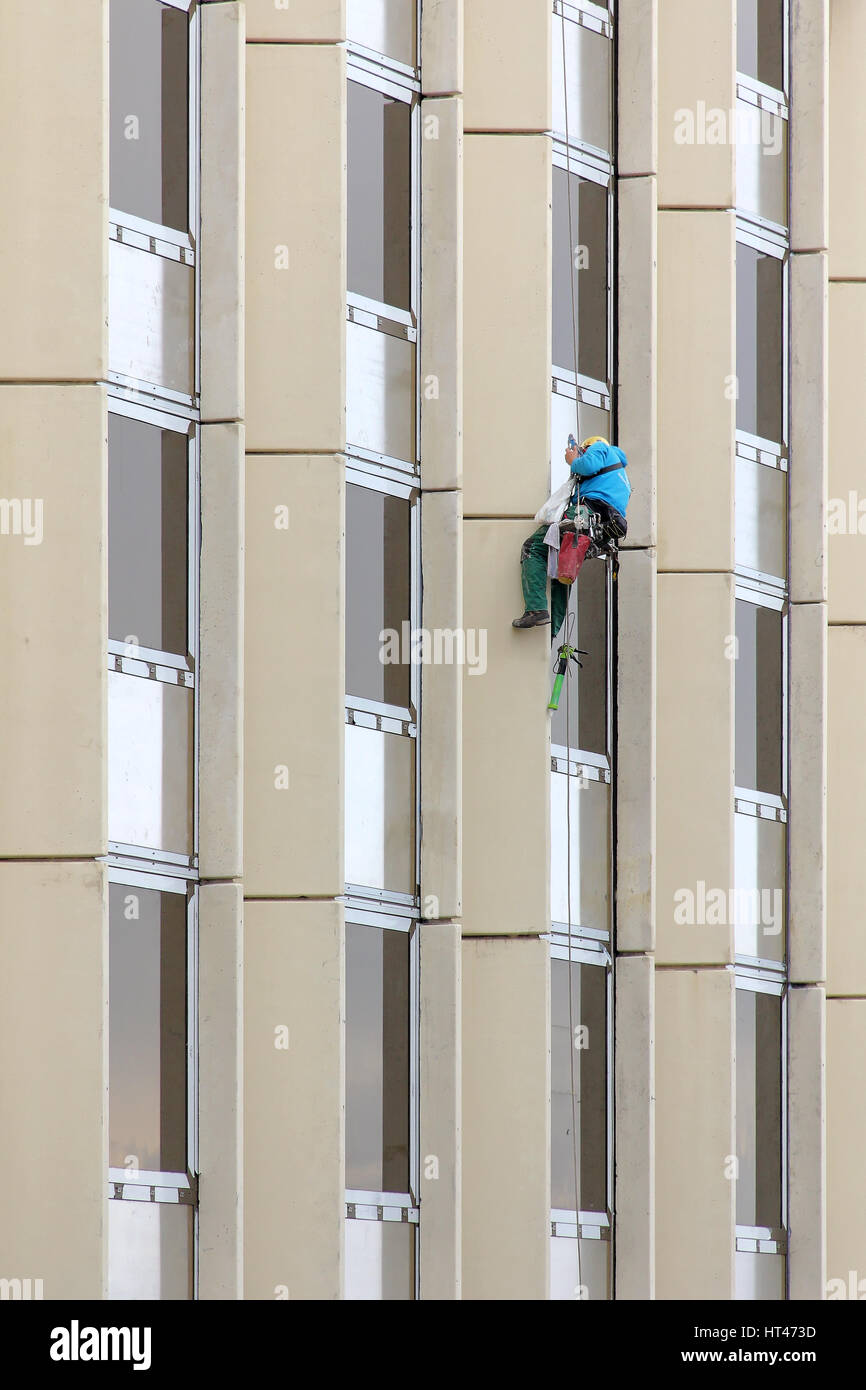 Alpinist window cleaning office building facade hanging cable .. Stock Photo