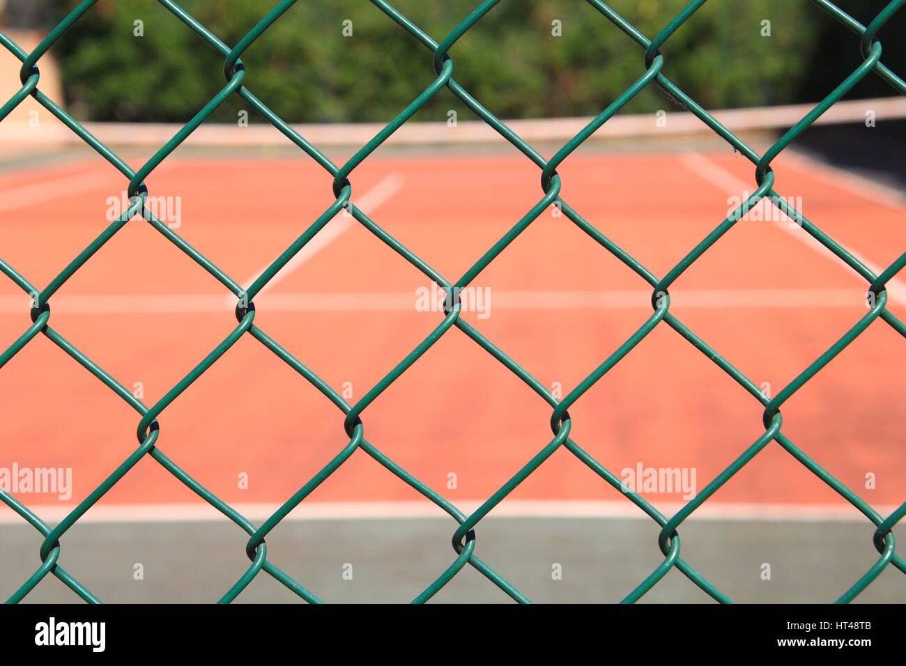 Tennis court seen through green wire mesh fence Stock Photo Alamy