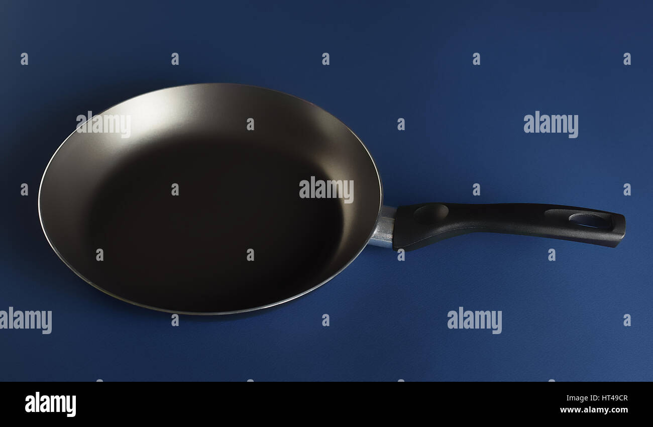 Nonstick fry pan on blue background perfect for your delicious recipes Stock Photo