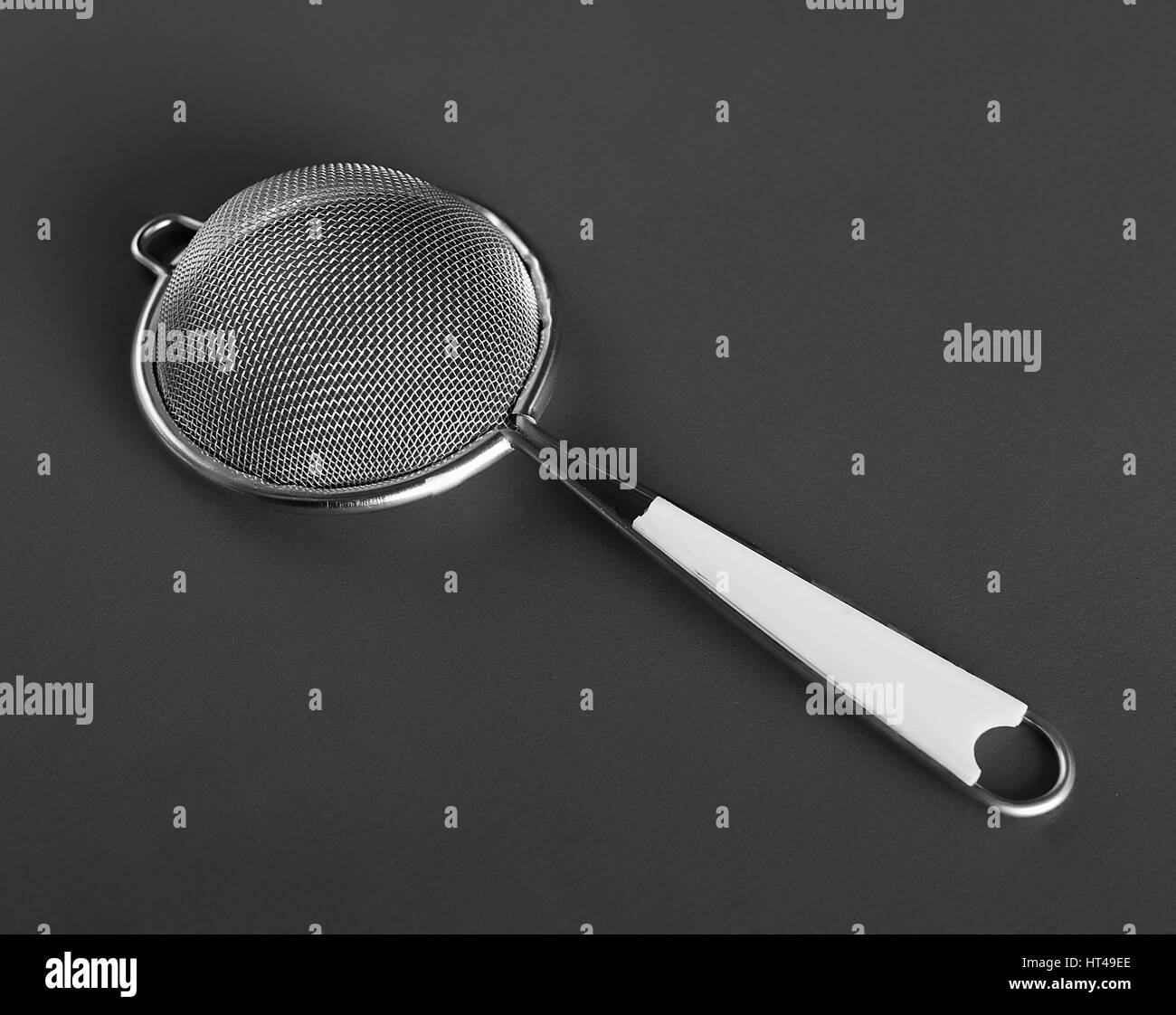 Metallic strainer with plastic handle, a modern kitchen utensil Stock