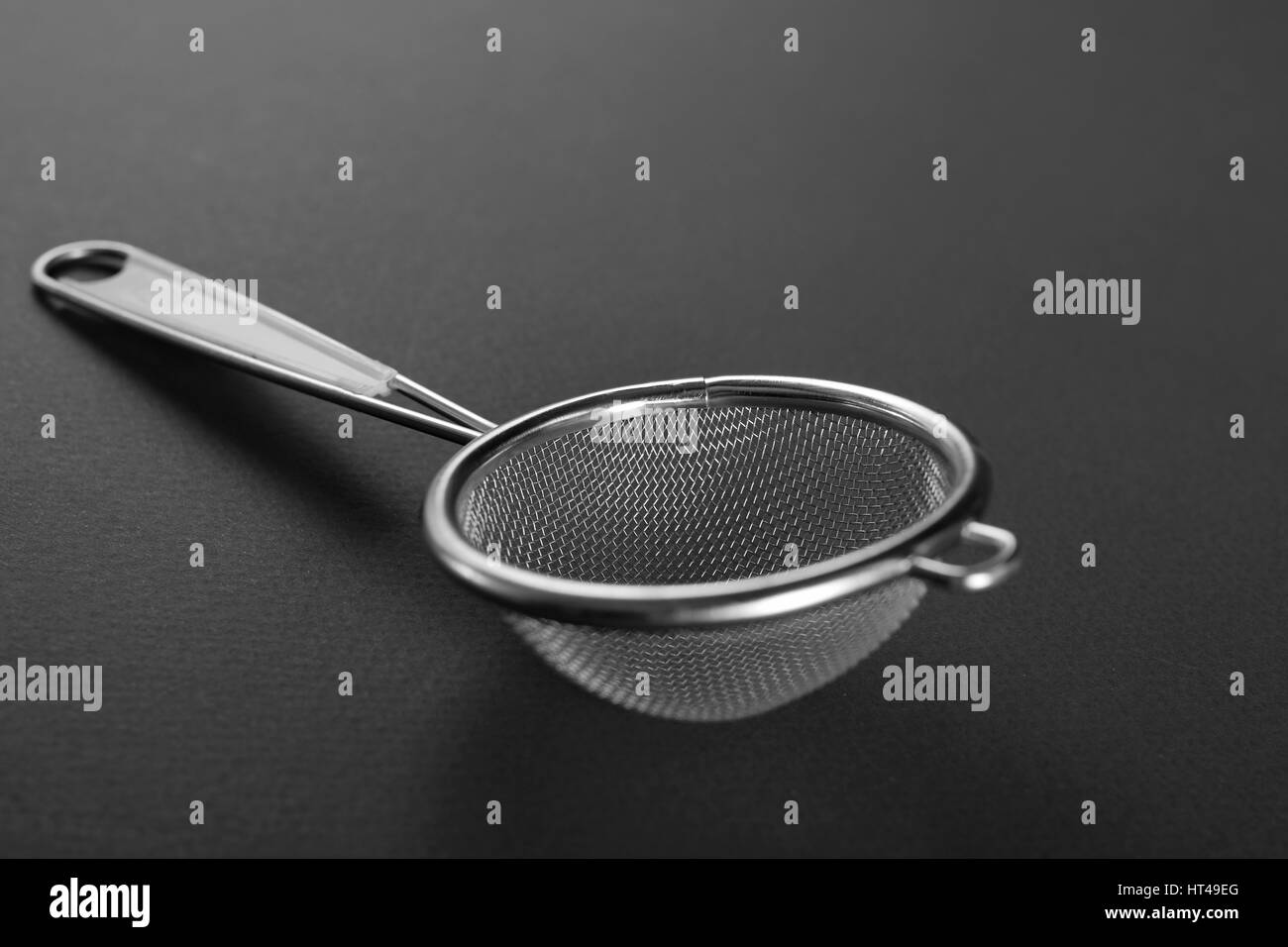 Metallic strainer with plastic handle, a modern kitchen utensil Stock