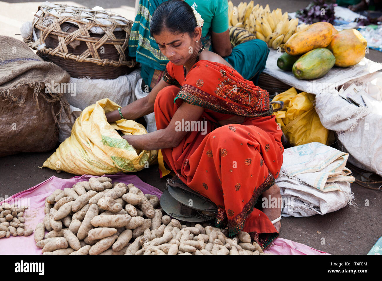 Woman selling goods at the Mapusa Market in North Goa, India. People from the surrounding come to Mapusa to sell their wares. Unlike other tourist-ori Stock Photo