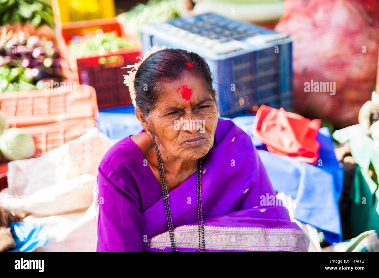 Woman selling goods at the Mapusa Market in North Goa, India. People from the surrounding come to Mapusa to sell their wares. Unlike other tourist-ori Stock Photo