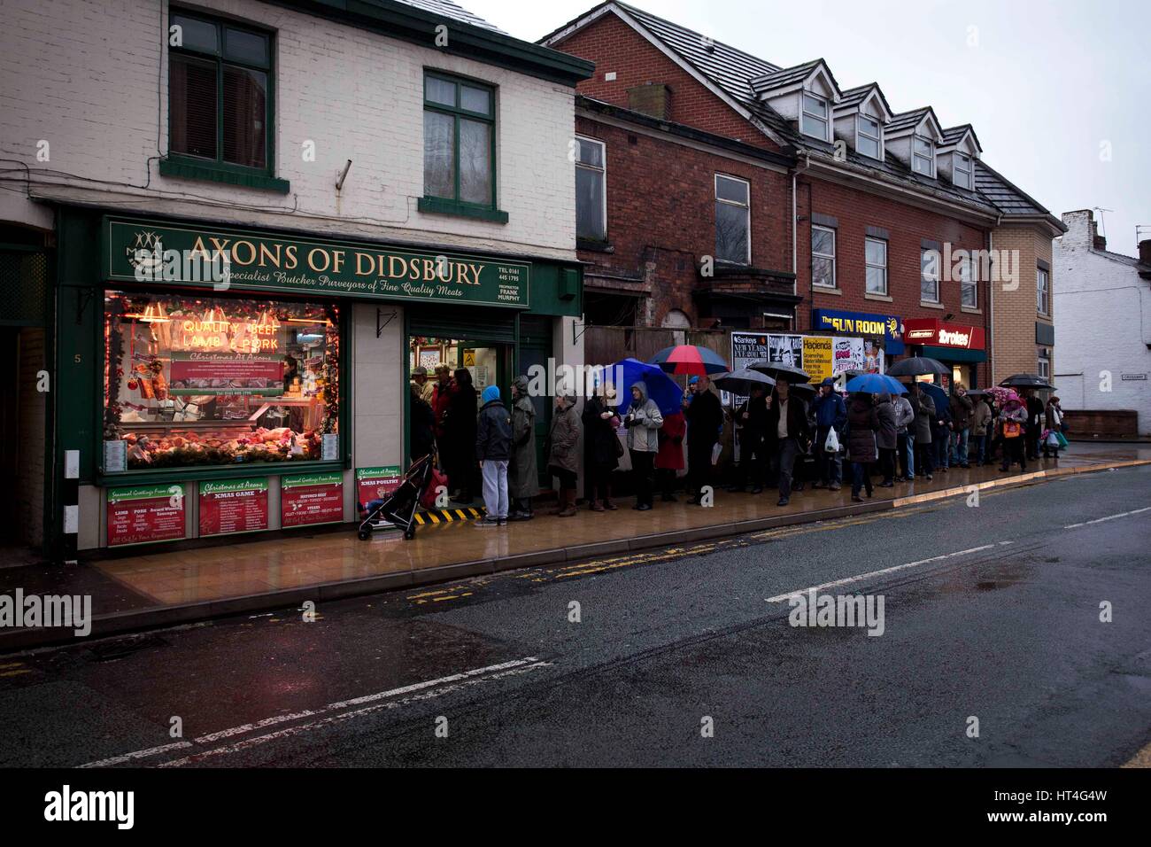 Queues of people outside a butchers shop ahead of Christmas .  Axons of Didsbury butchers Stock Photo