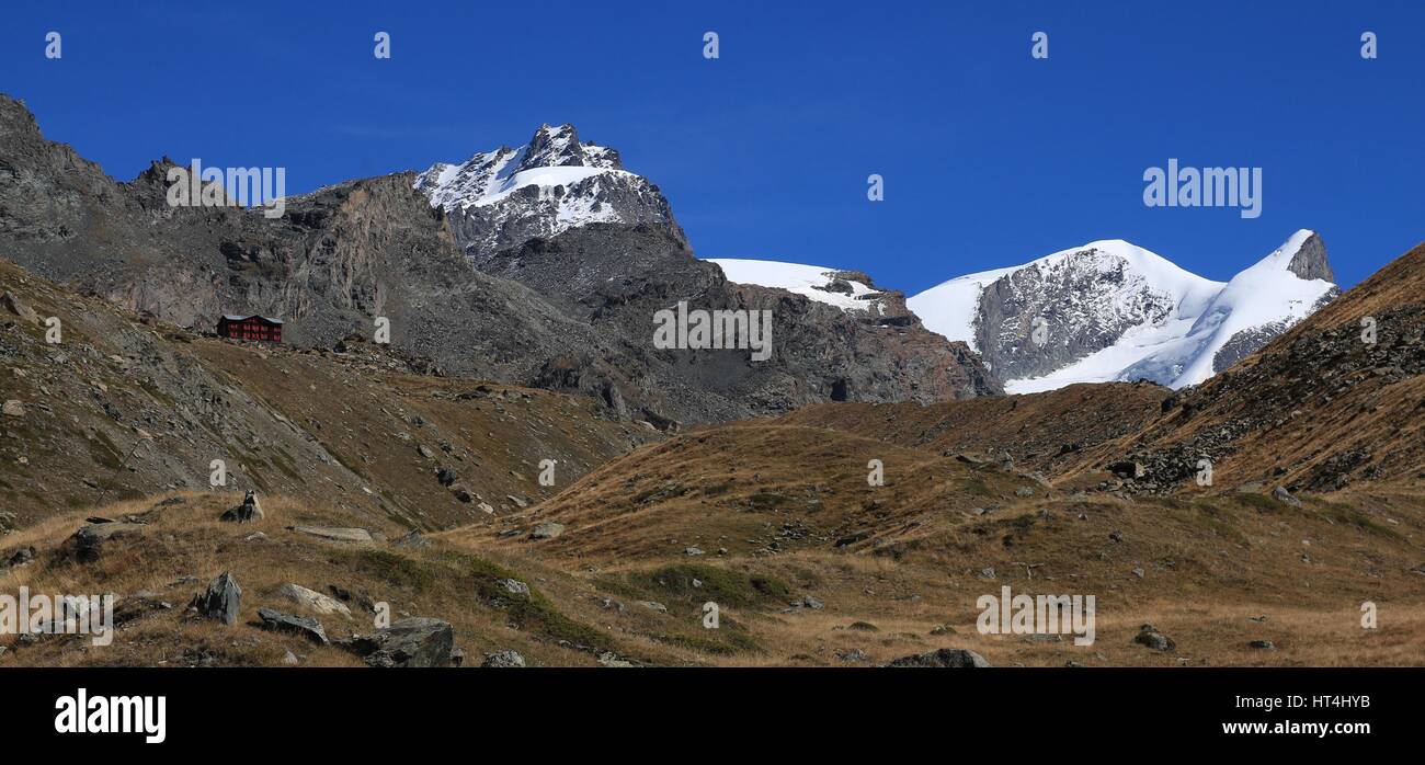 View from lake Stellisee towards Fluhalp. Peaks of mount Strahlhorn and Adlerhorn. Autumn day in Zermatt. Stock Photo