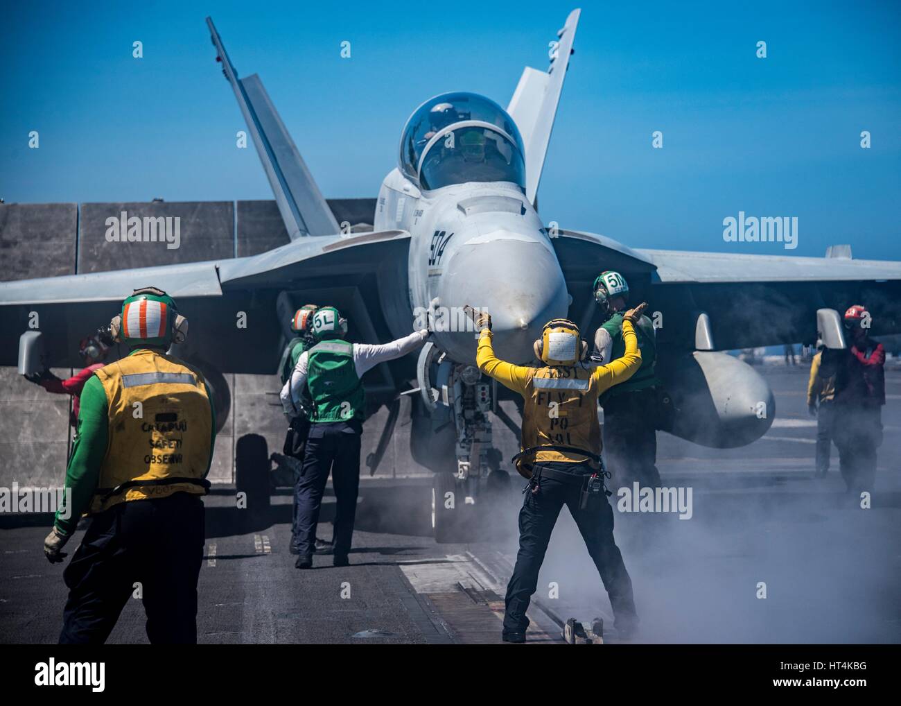 U.S. sailors prepare a U.S. Navy F/A-18F Super Hornet fighter aircraft for launch from the flight deck aboard the USN Nimitz-class aircraft carrier USS Carl Vinson February 22, 2017 in the South China Sea. Stock Photo