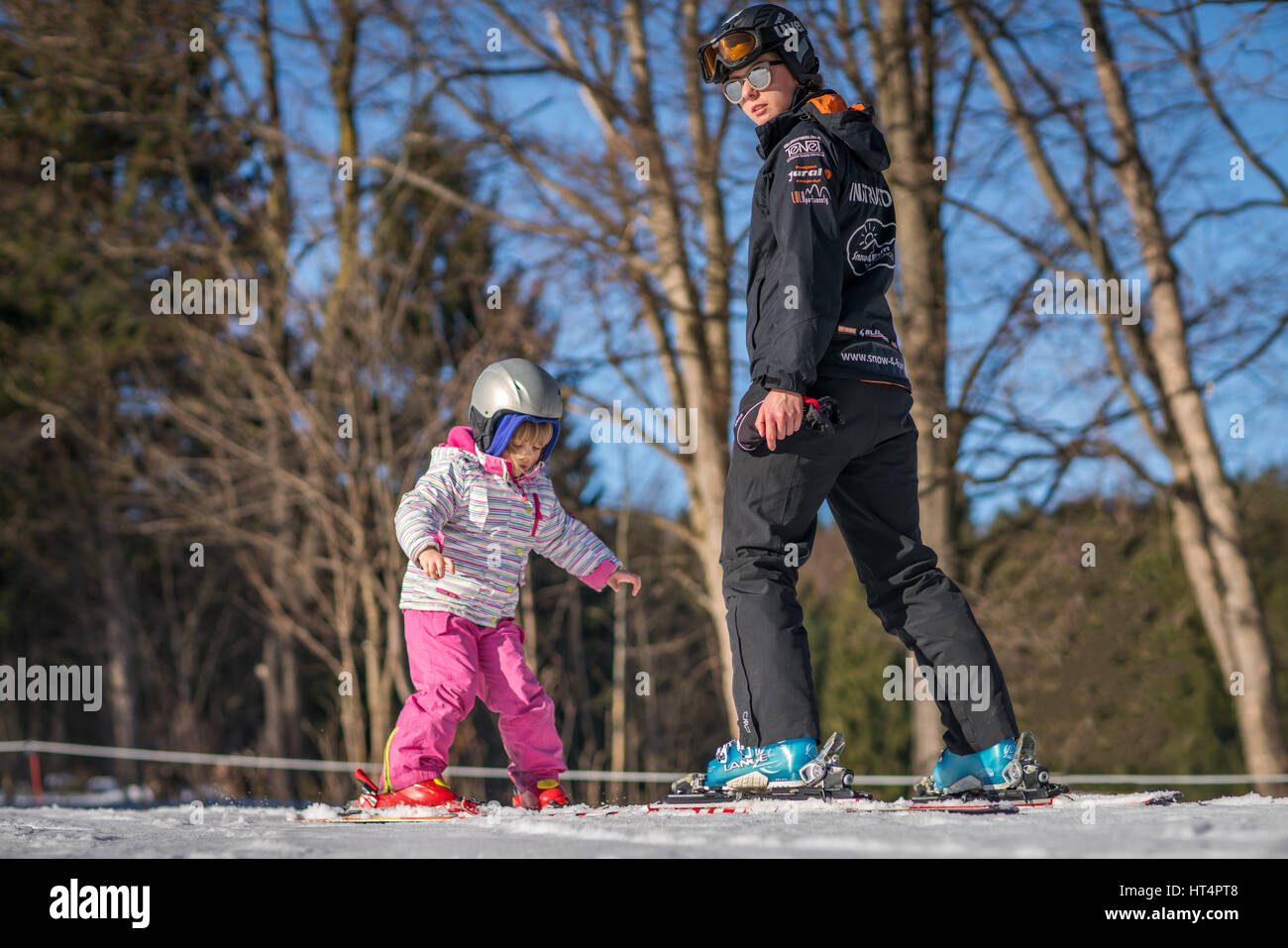 Szklarska Poreba, Poland -  February 2017 :  Little girl learning to ski taught by experienced female ski instructor, Szklarska Poreba, Karkonosze mou Stock Photo