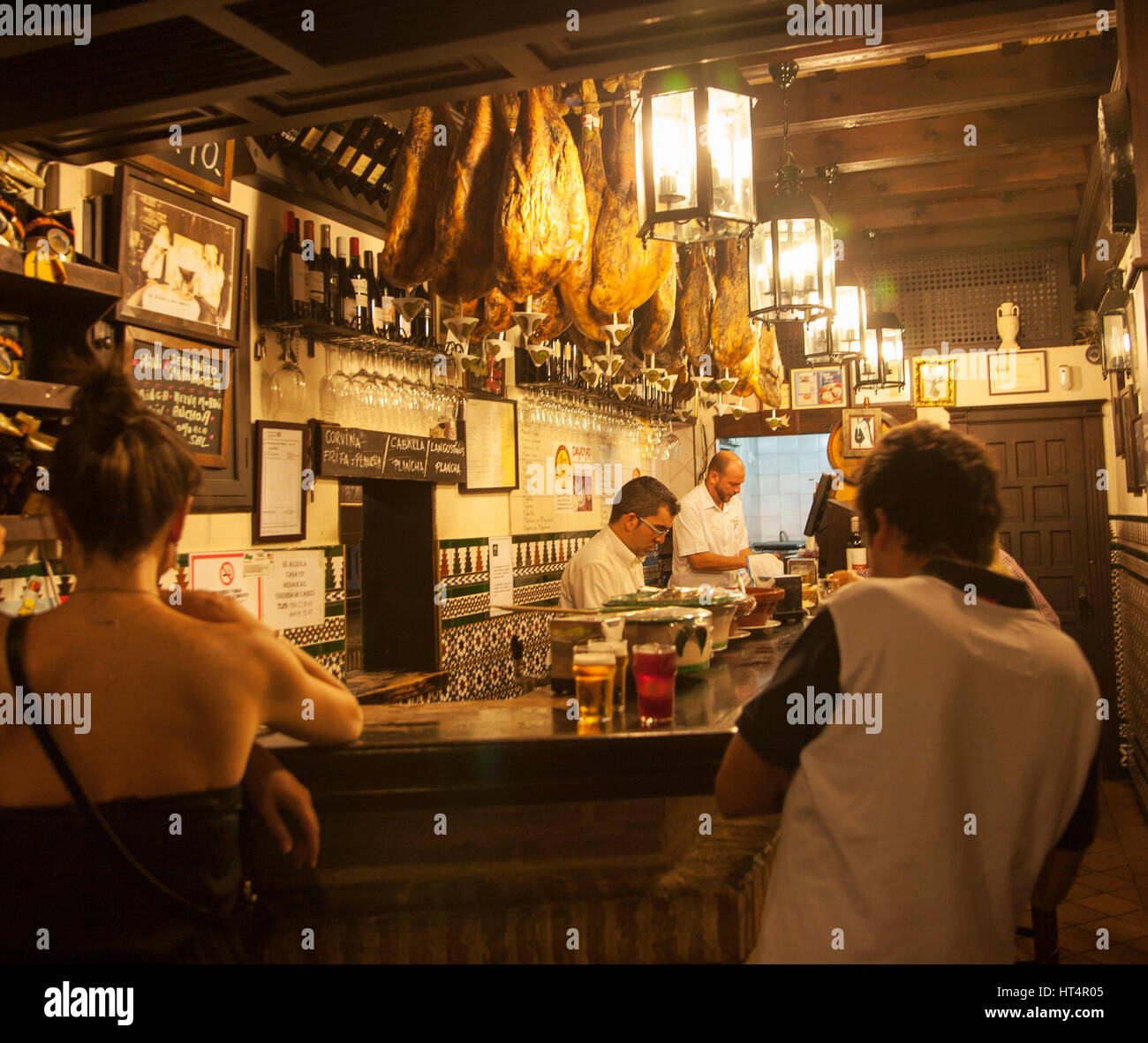 People inside typical traditional tapas bar in city centre of Seville