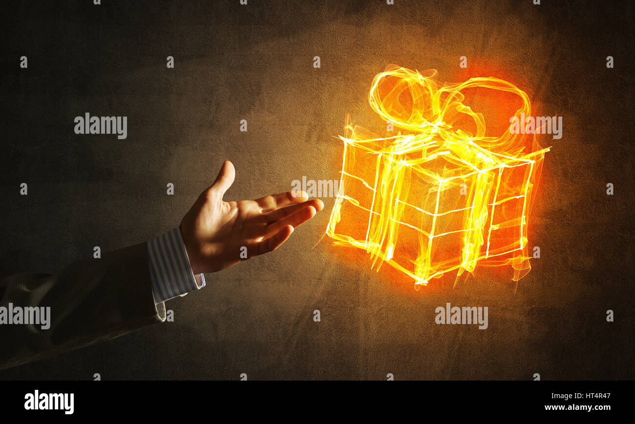 Businessman hand pointing at glowing fire gift box icon on dark ...
