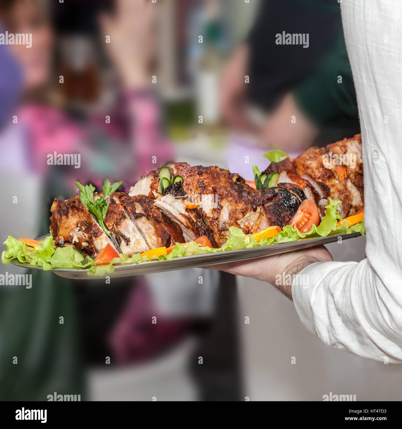 hand of the waiter giving a meat dish at restaurant Stock Photo