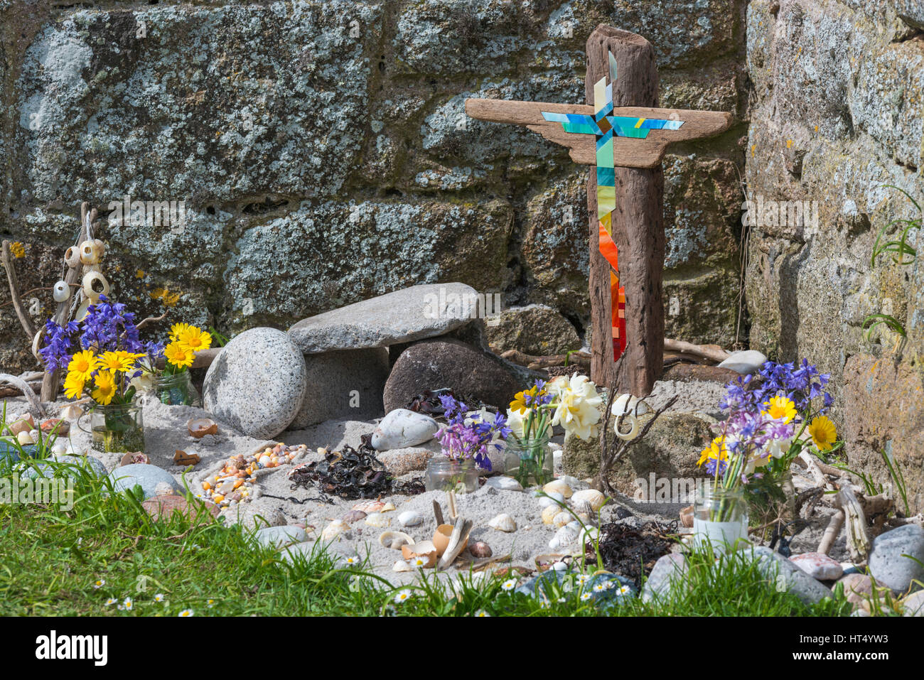 Cross, flowers, shells, pebbles of St Agnes schoolchildren’s Easter garden at St Agnes, Isles of Scilly, Scillies, Cornwall, UK in April Stock Photo