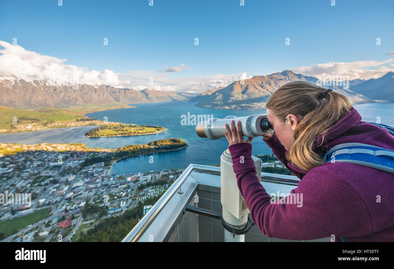 Woman looking through telescope, View of Lake Wakatipu and Queenstown from the Skyline Gondola, gondola cableway Stock Photo