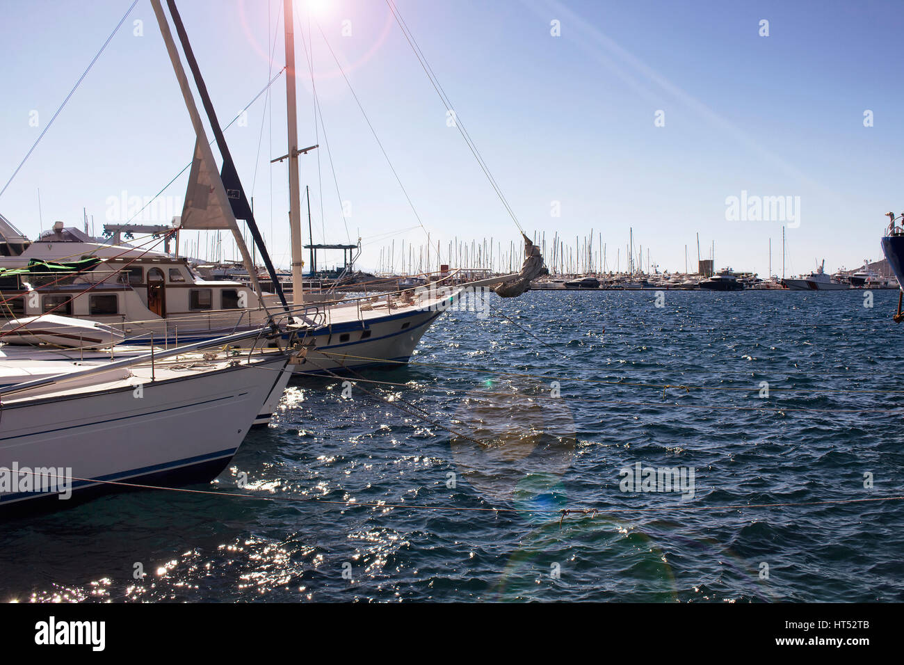 View of Yachts (sailing boats) parked at Yalikavak marina. Lens flare effects applied image. Stock Photo