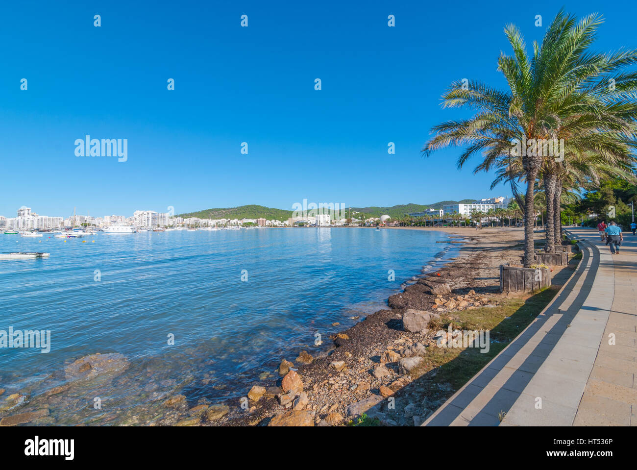 Ibiza sunshine on waterfront in Sant Antoni de Portmany,  Take a walk along main boardwalk, now a stone concourse, beside the beach in warm Ibiza. Stock Photo