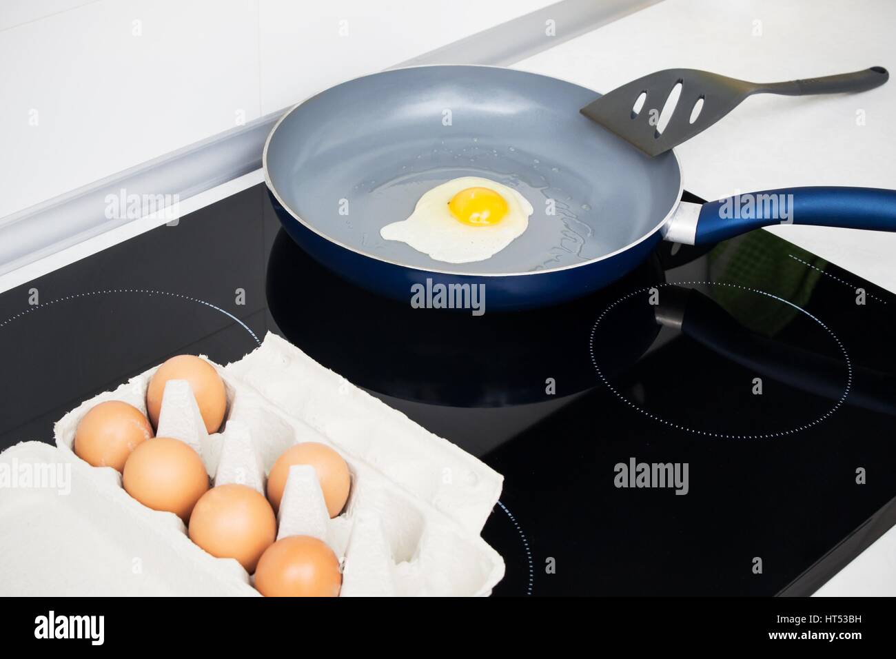 Fried egg in a frying pan on induction stove Stock Photo