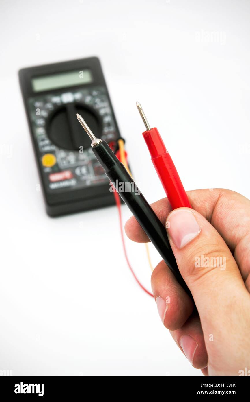 Multimeter with black and red wire in hands Stock Photo