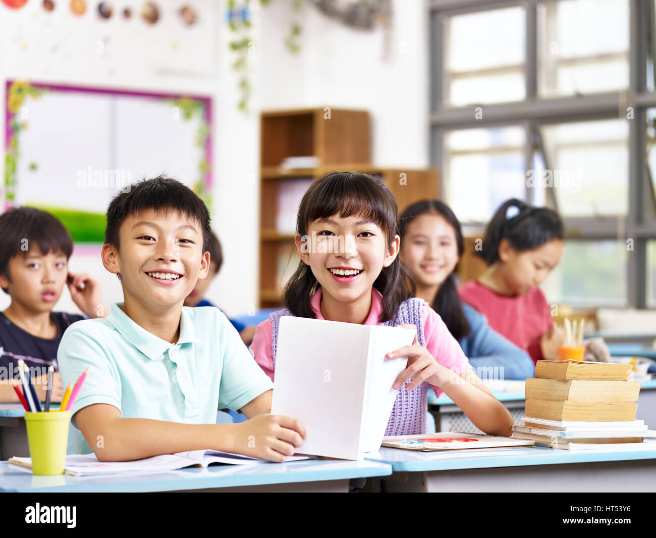 portrait of asian elementary school students in classroom looking at camera smiling. Stock Photo