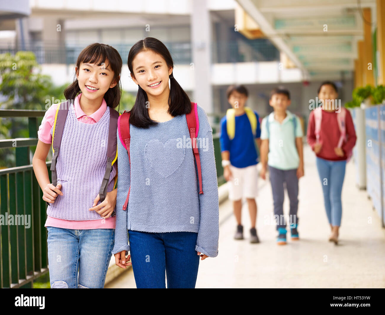 asian elementary school girls walking in classroom building. Stock Photo