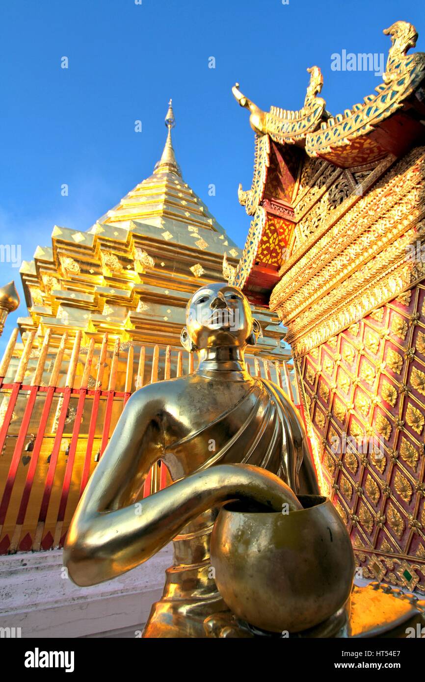 Golden buddha statue and pagoda against clear blue sky at Wat Phra That ...