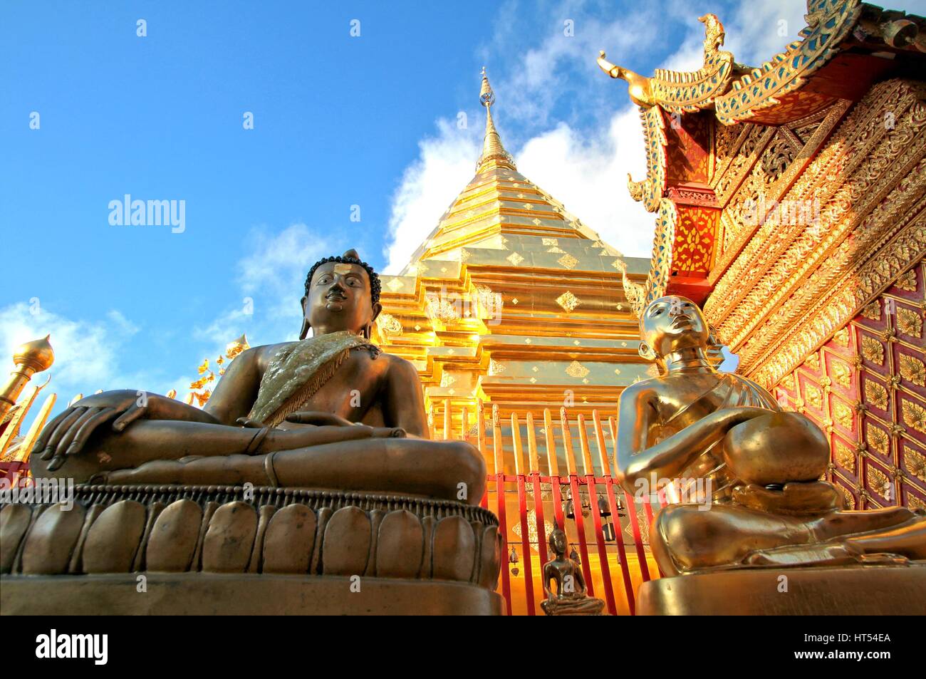 Buddha statues and golden pagoda against clear blue sky at Wat Phra ...
